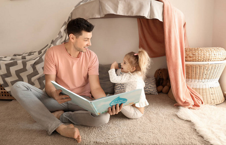 父亲与小女儿读睡前故事在小屋附近在家