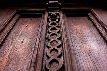 复古背景。一个古老的雕刻木门的元素, 装饰着大量的雕刻木元素模仿编织。古老古董的老式概念。漆老红木