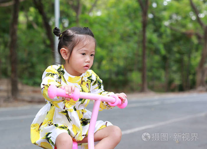 可爱的小女孩骑自行车在公园