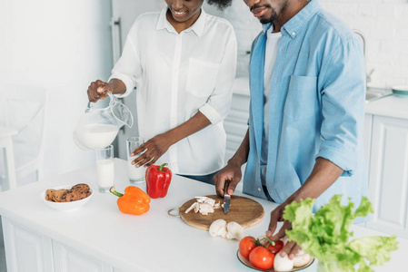 非洲裔美国妇女的部分看法倾吐牛奶入玻璃而丈夫在家里厨房做早餐
