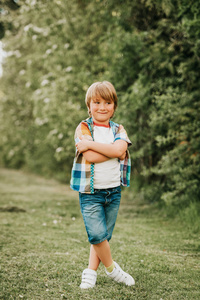 可爱的男孩夏天的肖像, 穿着五颜六色的衬衫和牛仔短裤, 在公园里玩在一个晴朗的日子