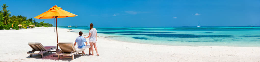 浪漫的情侣蜜月假期，宽全景完美的横幅的热带海滩上