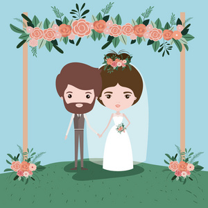 五颜六色的场面与草装饰的框架与花卉装饰品在木 poleswith 夫妇刚刚结婚下