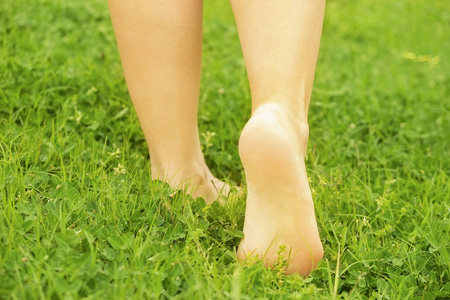 的脚在 mawed 草坪草。年轻女子赤脚在户外休息, 采取休息的概念。学生在大学校园围场