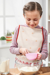 女孩烹调在家庭厨房, 筛面粉通过筛子, 健康食物概念