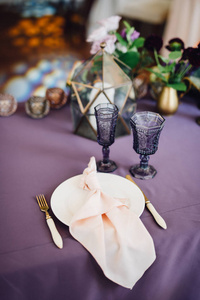 客人地方的特写与紫罗兰和白色餐具florarium 和花构成