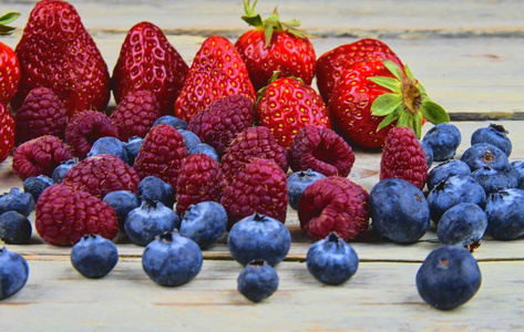 健康的混合水果和配料, 草莓, 覆盆子, 蓝莓。在质朴的白色木质背景浆果。特写。宏图像