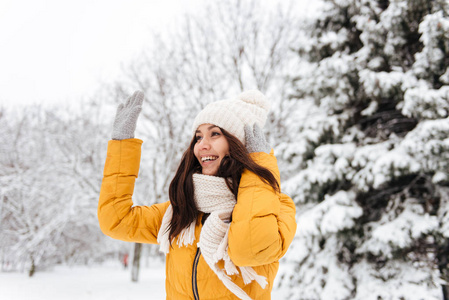 年轻的积极的妇女挥手和打招呼的人在雪园