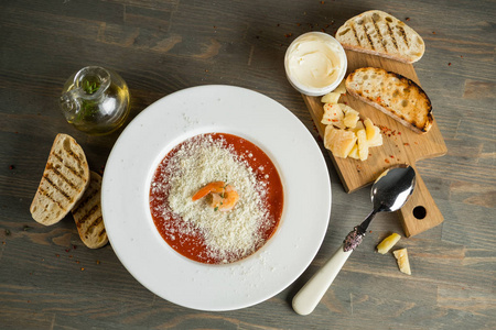 传统食品番茄奶油汤凉菜与奶酪, 虾和海鲜在木桌上的配料和新鲜面包