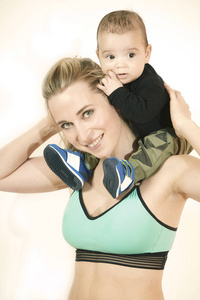年轻健身妇女与她的婴儿儿子运动细节