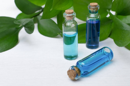 蓝色精华油酊在白色木质背景。替代医学。草药