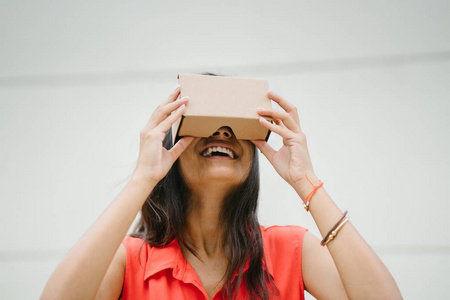 一位年轻而上镜的印度女性首次尝试虚拟现实护目镜。她笑着笑着高兴和惊讶的经验图片