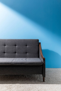 蓝色墙壁前的舒适灰色沙发