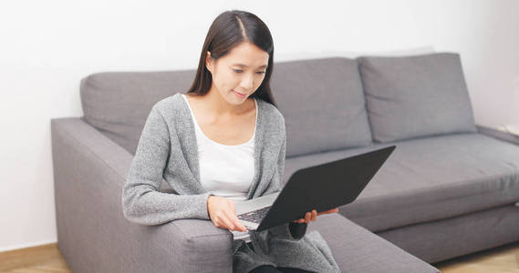 女人在家中使用的膝上型计算机