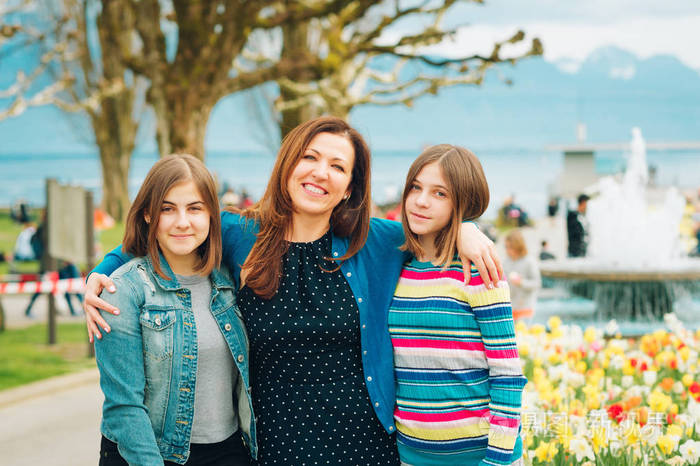 快乐母亲和两个年轻女孩的户外肖像