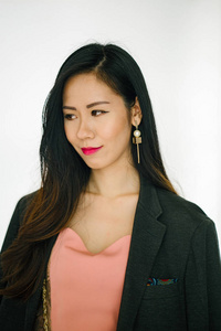 一个年轻的亚洲华人女性 博客, 影响力, 时尚 的肖像站在白色平原背景。她衣着时髦, 肩上披着一件男人的夹克。
