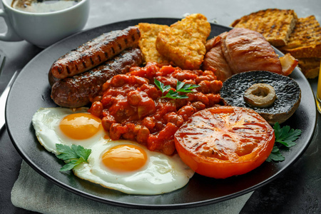 全英式早餐配培根香肠煎蛋焗豆炸薯片和蘑菇。杯咖啡