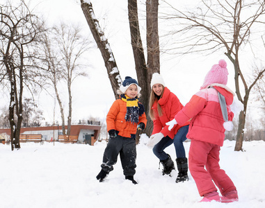 愉快的家庭在雪公园在冬天假期玩