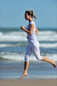 年轻女子在沙滩上慢跑
