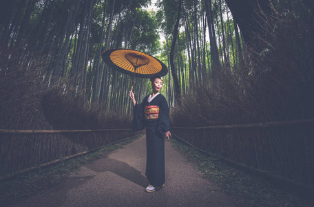 美丽的日本高级妇女走在竹林里