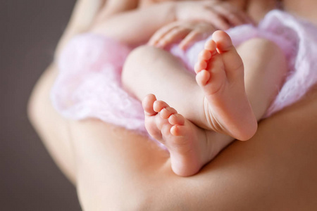 在白色和粉红色格子上关闭新出生婴儿脚的图片