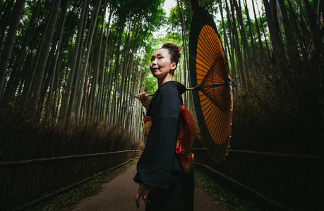 美丽的日本高级妇女走在竹林里图片