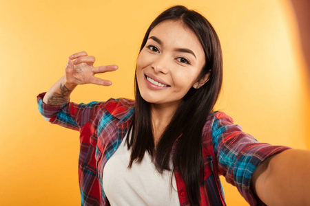 一个开朗的年轻亚洲女孩的肖像, 采取自拍