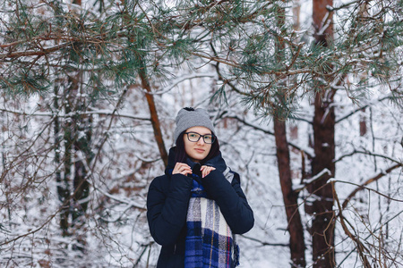 可爱的女孩在玻璃松树树枝下冬季在雪