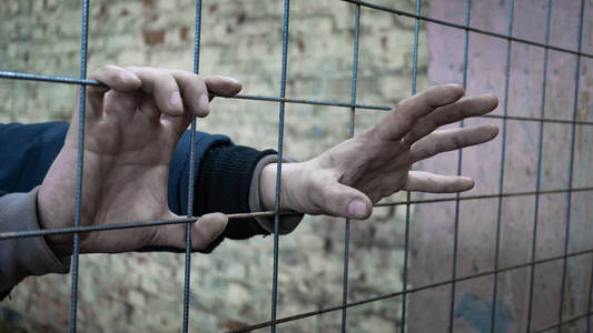 逃走把手放进监狱一个男人试图从酒吧后面逃走照片