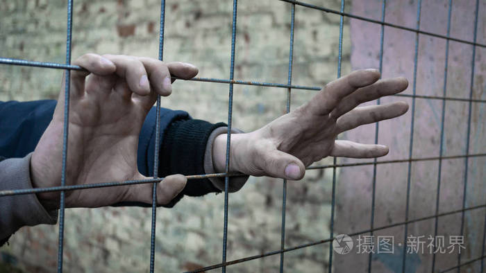 把手放进监狱一个男人试图从酒吧后面逃走照片-正版商用图片04btfw-摄