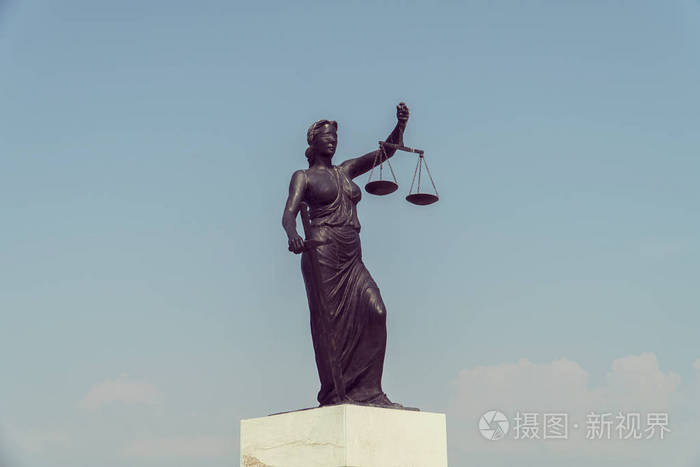 用剑和鳞片在前面的蓝色的多云的天空的正义女神像
