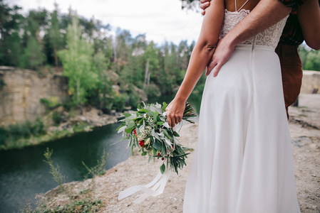 年轻夫妇站在山顶上的婚纱礼服与鲜花