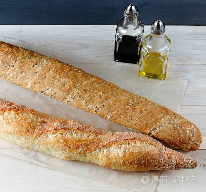 两个面包在牛皮纸上的木制背景