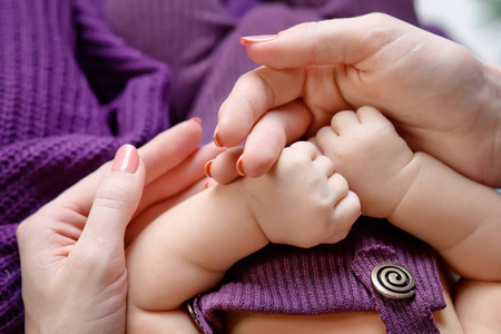新生婴儿的手在母亲手中。妈妈和她的孩子。快乐