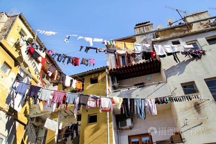 挂着洗衣房和墙壁.在建筑物间的晾衣线上洗涤.晾在旧门面窗外的衣服