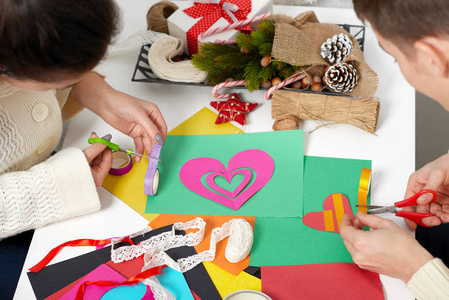 年轻夫妇为情人节做折纸装饰品, 顶视图浪漫和爱的概念