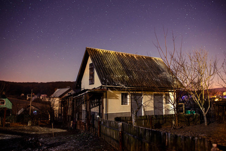 在夜晚的星空背景上的木房子里图片