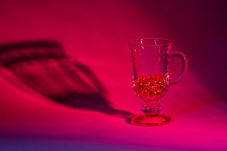 一杯红色的。一杯由红光照亮的玻璃珠
