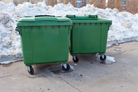 两个绿色回收容器在冬季公园