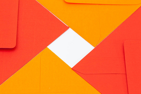 白色桌子上的红色和橙色信封