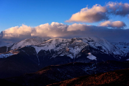 高山冬季风景在罗马尼亚的高山上与雪, 云彩在日落