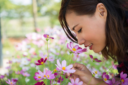 在花园里, 用宇宙之花嗅出欢快的女人的特写