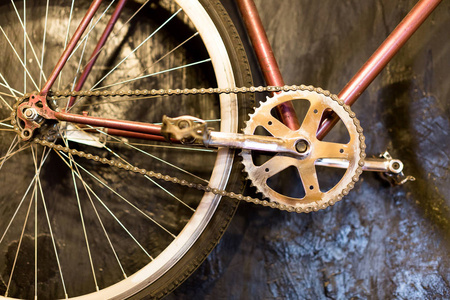 生活方式休闲时间工程理念。在黑色的墙上挂上的奇妙的古典自行车链, 它有干净的车轮和直辐条