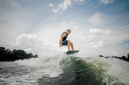 Wakesurf 骑手跳上一条河的波浪