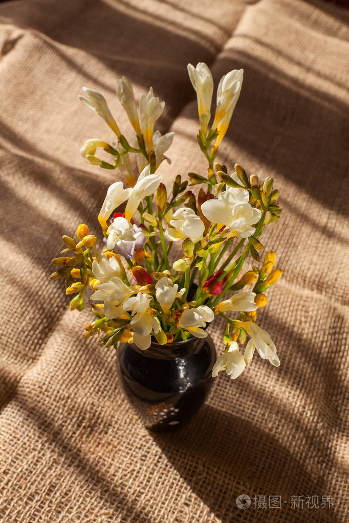 粗麻布上的小苍兰花束