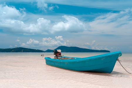 绿松石渔船在沙滩上用发动机背上, 清澈的水和山的背景。美丽的天气与蓝色多云的天空。柬埔寨 Samloem 岛