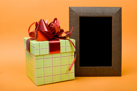 红丝带上橙色 ba 木相片框架和绿色礼品盒