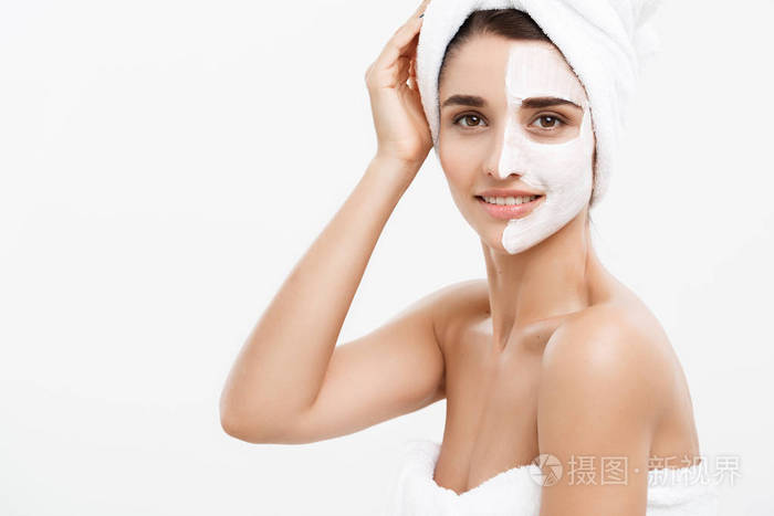 美容护肤理念美丽的白种女人脸上的肖像应用奶油面膜在她的面部皮肤白色背景