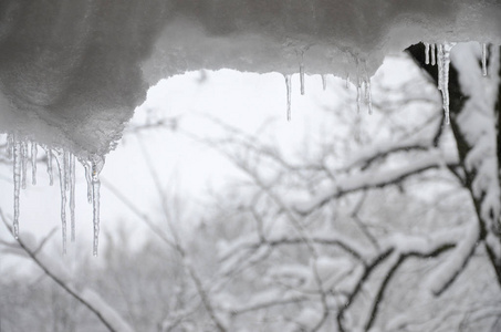 几个冰柱位于模糊的冬季视图, 从窗口