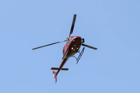 一架红色直升机在城市上空飞行